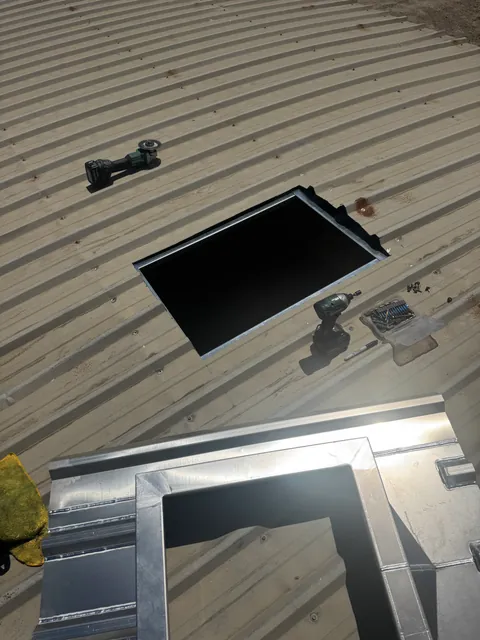 Open roof curb flashed into a metal roof
